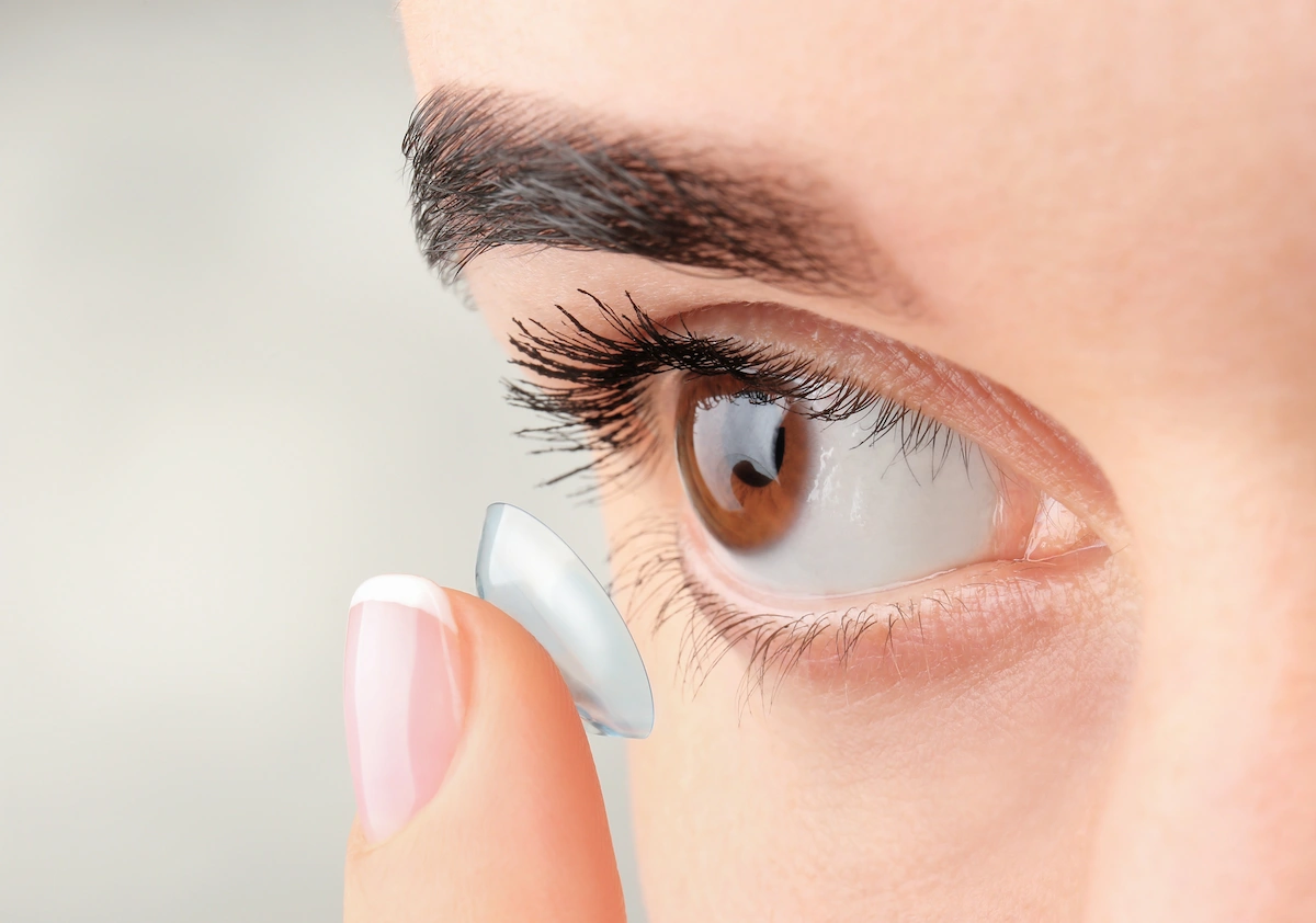 Close-up of person placing contact lens on eye